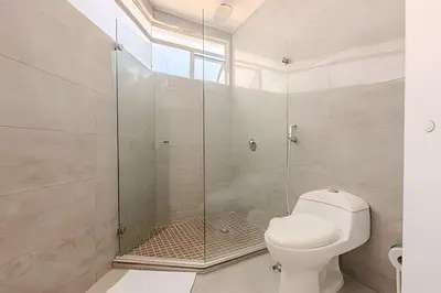a bathroom with a toilet and a glass shower at Espectacular vista al mar - Edificio Infinito 1002 in Cartagena de Indias