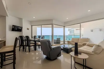 a living room with a couch and a table and chairs at Espectacular vista al mar - Edificio Infinito 1002 in Cartagena de Indias