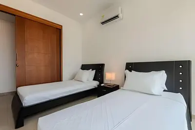 a bedroom with two beds and a wooden door at Espectacular vista al mar - Edificio Infinito 1002 in Cartagena de Indias