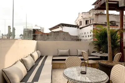a patio with a couch and tables and chairs at Hotel Casa Bianca by Faranda Boutique in Cartagena de Indias