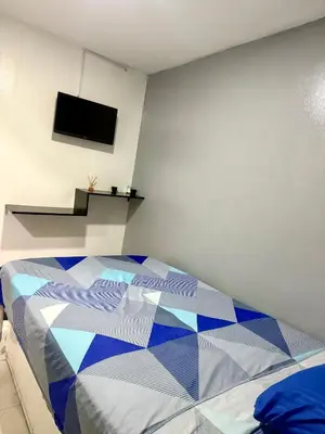 a bedroom with a bed with a tv on the wall at Hotel las nubes Barranquilla in Barranquilla