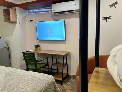 a room with a table and a tv on a wall at Almería Apt, Cozy Studio withTerrace Near Old Town in Cartagena de Indias