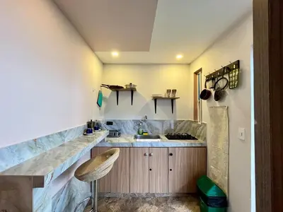 a kitchen with a counter with a sink and a stool at Almería Apt, Cozy Studio withTerrace Near Old Town in Cartagena de Indias