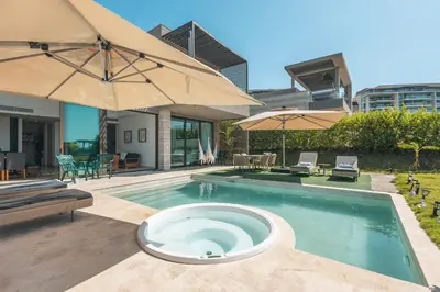 a swimming pool with an umbrella and chairs and tables at 4BR Caribbean Deluxe Villa 3C in Cartagena de Indias
