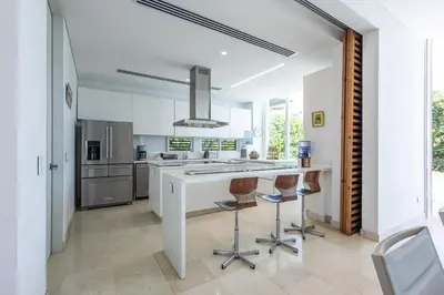 a kitchen with a large white island with bar stools at Brand new 4BR Villa at Calablanca in Cartagena de Indias