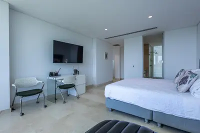 a bedroom with a bed and a desk and a tv at Brand new 4BR Villa at Calablanca in Cartagena de Indias