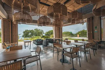 a restaurant with tables and chairs and a large window at Brand new 4BR Villa at Calablanca in Cartagena de Indias