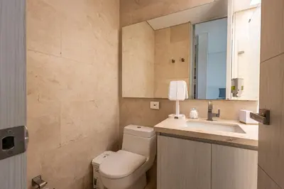 a bathroom with a toilet and a sink and a mirror at Brand new 4BR Villa at Calablanca in Cartagena de Indias