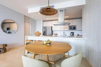 a kitchen and dining room with a wooden table and chairs at 4BR Seaview Apartment at Calablanca D5 in Cartagena de Indias