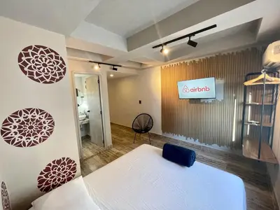 a bedroom with a white bed and a sign on the wall at Almería Apt, Spacious Studio Near Old Town in Cartagena de Indias
