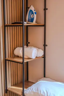 a metal cage with towels on it next to a bed at Almería Apt, Spacious Studio Near Old Town in Cartagena de Indias