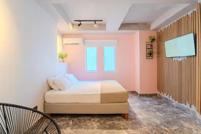 a small bedroom with a bed and a chair at Almería Apt, Stylish Modern Studio Near Centro in Cartagena de Indias