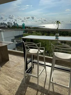 a table and two chairs on a balcony with the ocean at Cartagena Beach - Sea View - Airport 5 min in Cartagena de Indias