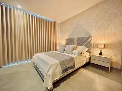 a bedroom with a bed and a window with curtains at Apartamento con vista al mar y acceso a la playa in Santa Marta