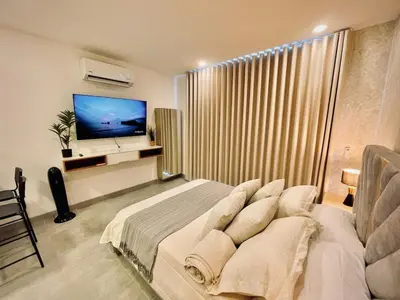 a bedroom with a large bed and a television at Apartamento con vista al mar y acceso a la playa in Santa Marta