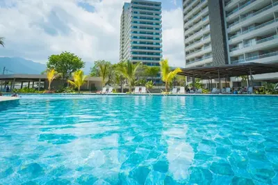a large blue swimming pool with buildings in the background at Apartamento con vista al mar y acceso a la playa in Santa Marta