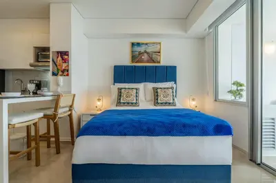 a bedroom with a blue and white bed and a desk at CB Lujoso Apartasuit -Vista al mar-linda piscina-cerca al Aeropuerto in Cartagena de Indias