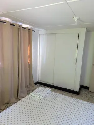 a room with white curtains and a bed in it at English power Exotic point in Barranquilla
