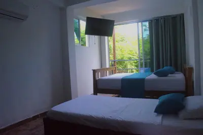 a bedroom with two beds and a window with a view at Mango Tree Island 420 in Tierra Bomba