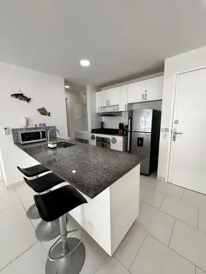 a kitchen with a counter and two stools in it at Exclusivo Apartamento con playa y piscinas Morros Cartagena in Cartagena de Indias