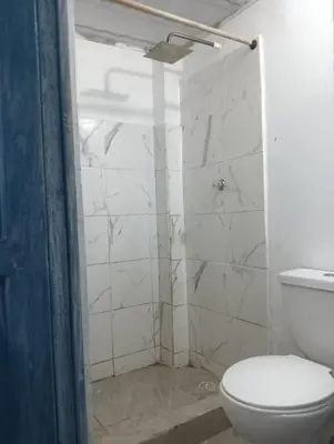a white bathroom with a toilet and a shower at Casamar sol caribe in Cartagena de Indias