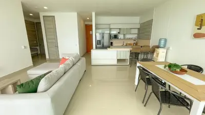 a living room with a couch and a kitchen at Magico Apartamento Frente al Mar 3 Habitaciones BM91 in Coveñitas