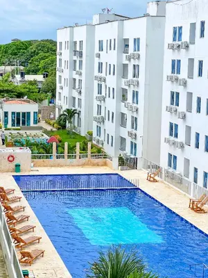 a pool in front of two tall buildings at Caribe Familiar 504 in Coveñas