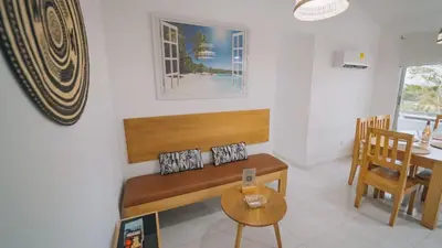 a living room with a bench and a table at Caribe Familiar 504 in Coveñas