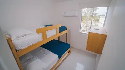 a small bedroom with a bunk bed and a window at Caribe Familiar 504 in Coveñas