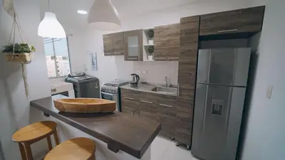 a kitchen with a wooden counter and a refrigerator at Caribe Familiar 504 in Coveñas