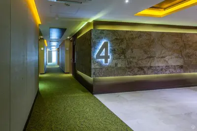 a hallway with a number four on a stone wall at Sky Collection Lifestyle Hotel & Suites Barranquilla in Barranquilla