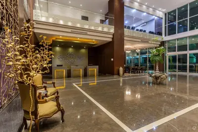 a lobby with chairs and tables in a building at Sky Collection Lifestyle Hotel & Suites Barranquilla in Barranquilla