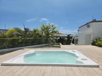 a hot tub on a deck with a mountain in the background at Exclusive Apartment with Private Jacuzzi in Cartagena de Indias