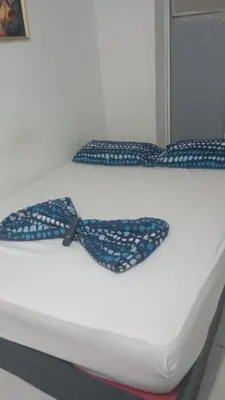 a bed with a blue and white bow tie on it at hotel restaurante doña nerta in Cartagena de Indias