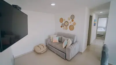 a living room with a couch and a flat screen tv at Azul Caribe 104 in Coveñas