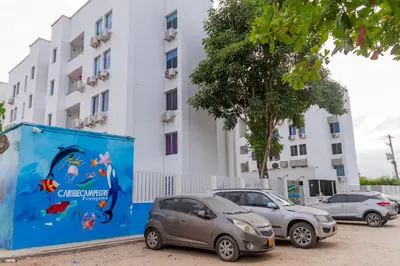 two cars parked in a parking lot in front of a building at Prada Caribe 303 in Coveñas