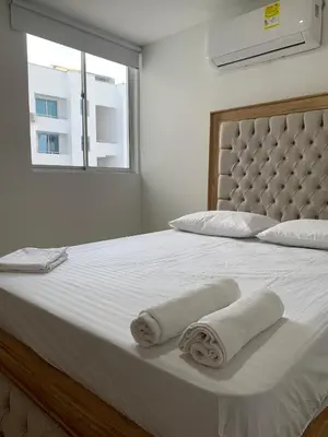 a bedroom with a large white bed with towels on it at Prada Caribe 303 in Coveñas