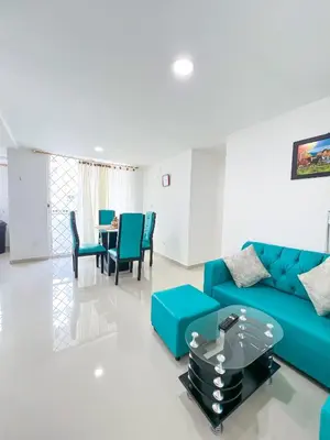 a living room with a blue couch and a table at Celeste Caribe 101A in Coveñas