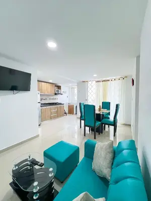 a living room with a blue couch and a table at Celeste Caribe 101A in Coveñas