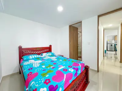 a bedroom with a bed with a colorful comforter at Celeste Caribe 101A in Coveñas