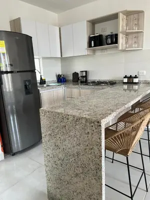 a kitchen with a granite counter top and a refrigerator at Apartamento Cartagena Moderno y Comodo in Manzanillo del Mar