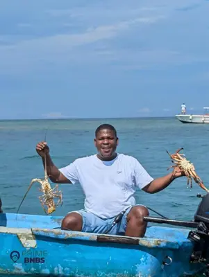 a man sitting in a boat holding up seafood at Beach Front - Luxury High Rise - Dubai Style in Cartagena de Indias