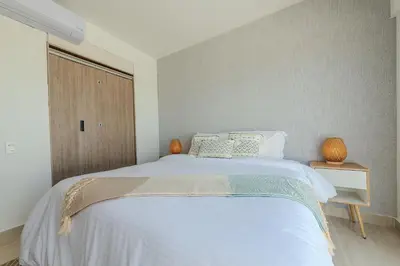a bedroom with a large white bed and a window at Condominio Moderno nuevo Trevi in Cartagena de Indias
