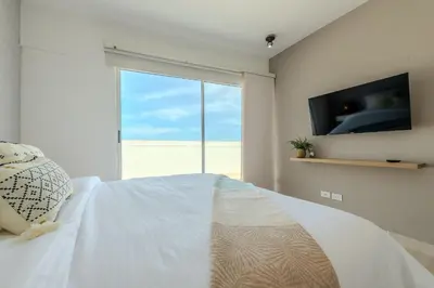 a bedroom with a bed with a tv and a window at Condominio Moderno nuevo Trevi in Cartagena de Indias