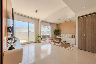 a living room with a white couch and a large window at Condominio Moderno nuevo Trevi in Cartagena de Indias