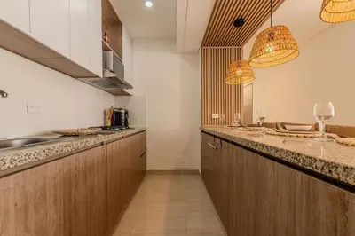 a kitchen with wooden cabinets and two lights at Condominio Moderno nuevo Trevi in Cartagena de Indias