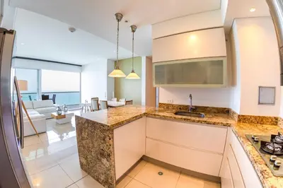a kitchen with marble counter tops and a living room at luxury Aparment Ocean view H2 condominium apto 2105 in Cartagena de Indias