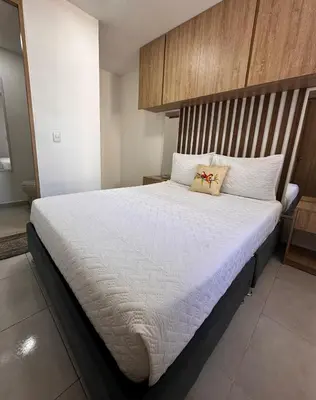 a bedroom with a large bed with white sheets at Apartment in Cartagena Sea View & Ocean View Cerca al centro Histórico in Cartagena de Indias