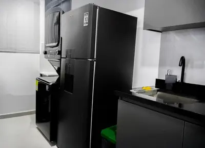 a kitchen with a black refrigerator and a sink at New modern apartment in Barranquilla