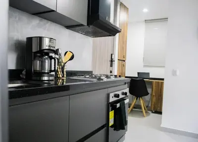 a kitchen with a black counter top with a coffee maker at New modern apartment in Barranquilla